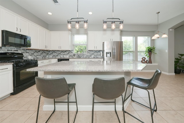 16826 Paynes Creek Dr, Cypress, TX 77433 - kitchen featuring black appliances, backsplash, a breakfast bar area, white cabinets, and recessed lighting