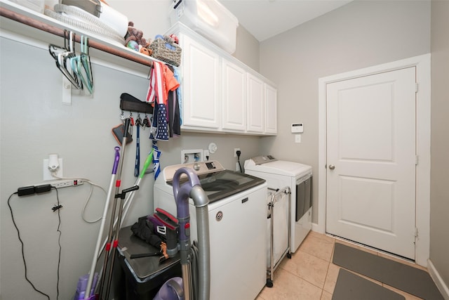 16826 Paynes Creek Dr, Cypress, TX 77433 - laundry area with washer and clothes dryer, cabinet space, and light tile patterned flooring
