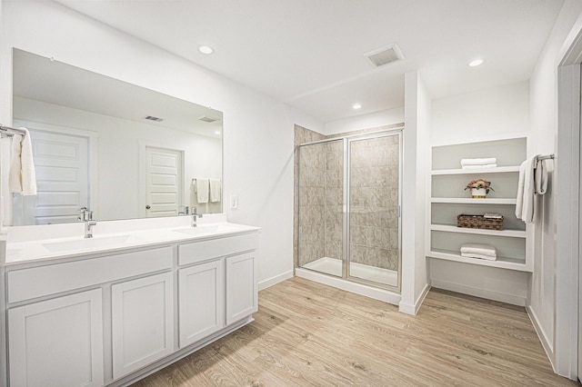 31723 Kellan Grove Ct, Fulshear, TX 77441 - bathroom featuring wood finished floors, a shower stall, double vanity, baseboards, and recessed lighting