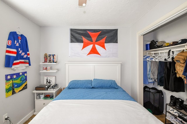 4623 Tealgate Dr, Spring, TX 77373 - bedroom featuring a closet, a textured ceiling, baseboards, and wood finished floors