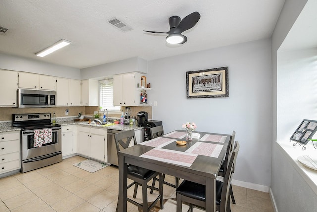 4623 Tealgate Dr, Spring, TX 77373 - kitchen featuring stainless steel appliances, light tile patterned floors, a ceiling fan, white cabinets, and open shelves