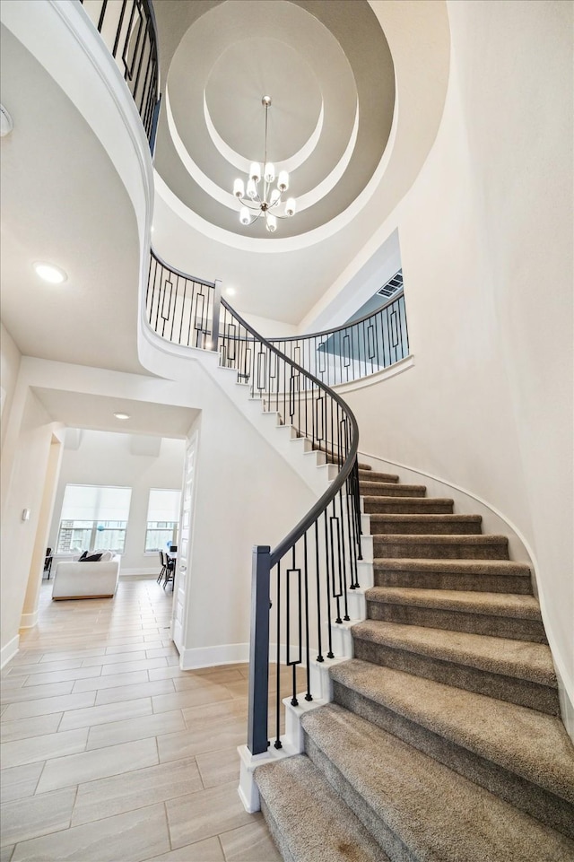 12434 Tullich Run Dr, Humble, TX 77346 - stairway featuring baseboards, a chandelier, a towering ceiling, and recessed lighting