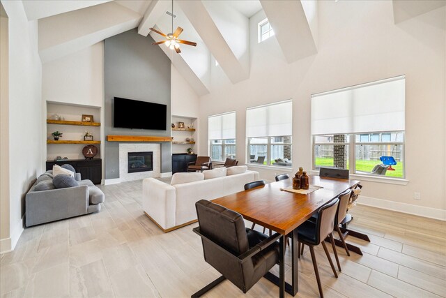 12434 Tullich Run Dr, Humble, TX 77346 - dining space featuring high vaulted ceiling, a glass covered fireplace, beam ceiling, healthy amount of natural light, and baseboards