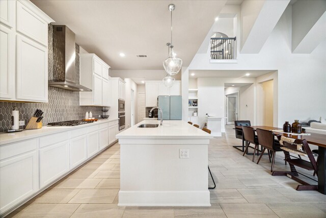 12434 Tullich Run Dr, Humble, TX 77346 - kitchen featuring wall chimney range hood, a sink, stainless steel appliances, tasteful backsplash, and white cabinets