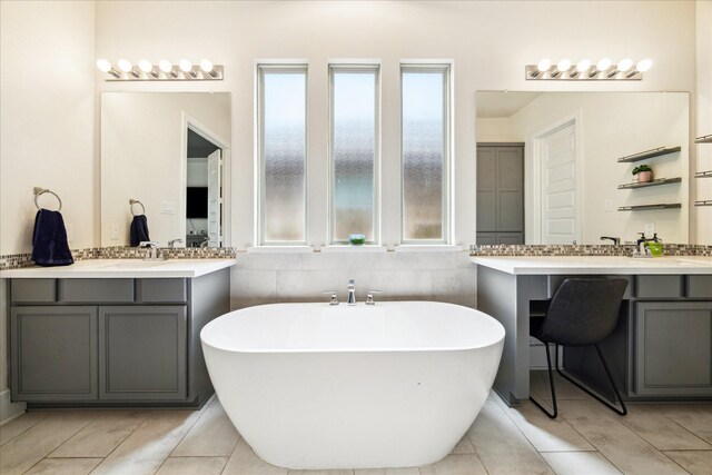 12434 Tullich Run Dr, Humble, TX 77346 - bathroom featuring two vanities, a soaking tub, and tile patterned flooring