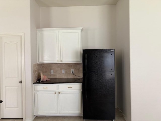 3643 Goldleaf Trail Dr, Katy, TX 77449 - kitchen with freestanding refrigerator, dark countertops, tasteful backsplash, white cabinets, and baseboards