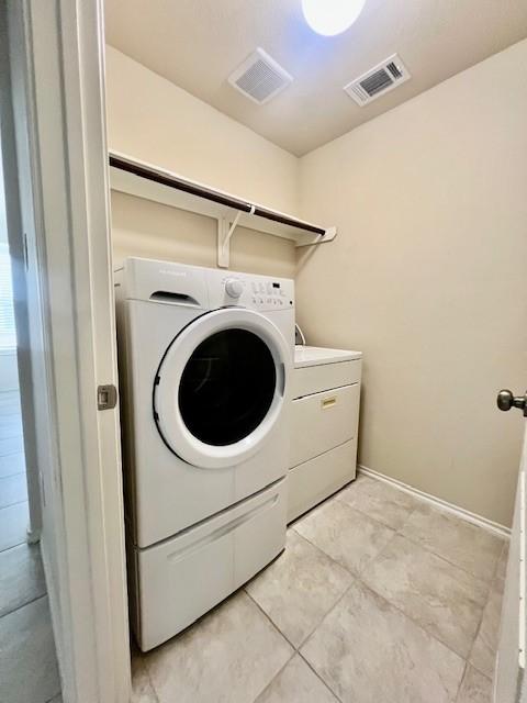 3643 Goldleaf Trail Dr, Katy, TX 77449 - laundry area featuring independent washer and dryer, light tile patterned floors, and baseboards