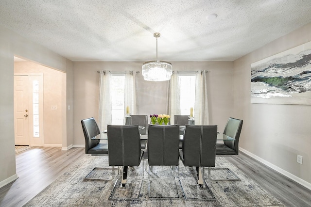 19727 Teller Blvd, Spring, TX 77388 - dining area featuring wood finished floors, a chandelier, a textured ceiling, and baseboards