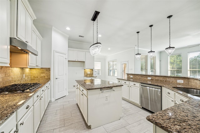 1811 Leela Springs Dr, Conroe, TX 77304 - kitchen featuring appliances with stainless steel finishes, under cabinet range hood, a sink, a kitchen island, and ornamental molding