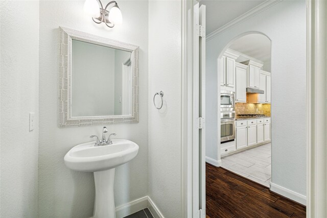 1811 Leela Springs Dr, Conroe, TX 77304 - bathroom with wood finished floors, baseboards, tasteful backsplash, and ornamental molding