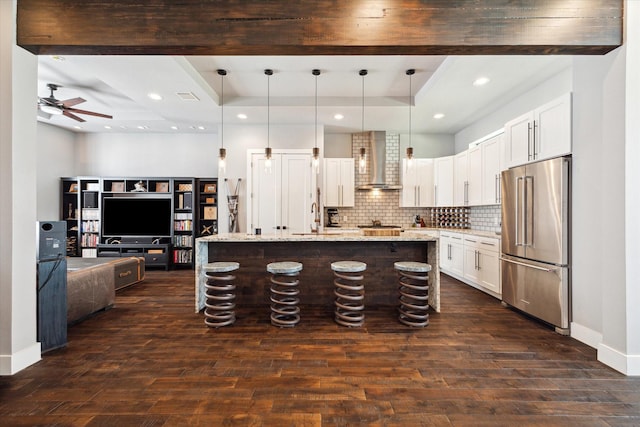 5121 Elysian St, Houston, TX 77009 - kitchen with high quality fridge, wall chimney exhaust hood, open floor plan, ceiling fan, and dark wood-type flooring