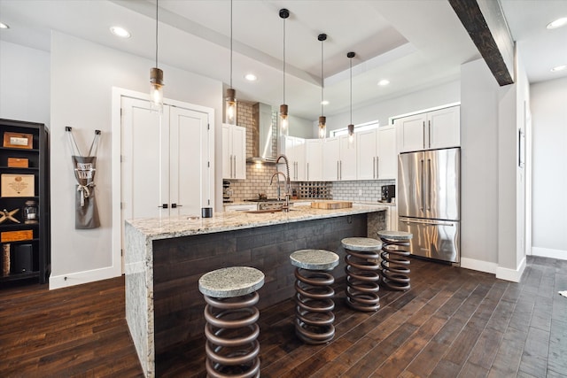 5121 Elysian St, Houston, TX 77009 - kitchen featuring high end refrigerator, baseboards, wall chimney range hood, dark wood-style flooring, and recessed lighting