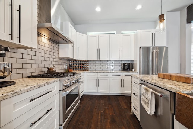 5121 Elysian St, Houston, TX 77009 - kitchen featuring appliances with stainless steel finishes, wall chimney exhaust hood, white cabinetry, dark wood-style floors, and backsplash