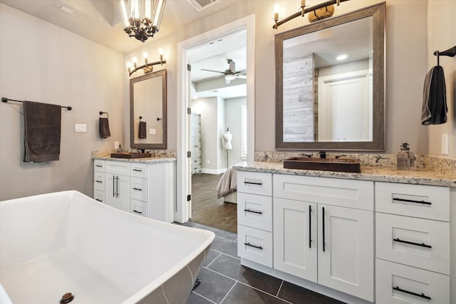 5121 Elysian St, Houston, TX 77009 - bathroom with two vanities, a freestanding tub, a chandelier, tile patterned flooring, and a ceiling fan