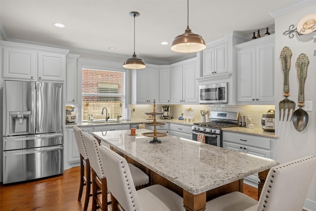 2532 Hailes Ln, College Station, TX 77845 - kitchen featuring stainless steel appliances, a sink, white cabinets, a breakfast bar, and decorative backsplash