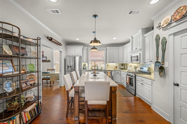 2532 Hailes Ln, College Station, TX 77845 - kitchen with stainless steel appliances, crown molding, backsplash, white cabinets, and light stone countertops