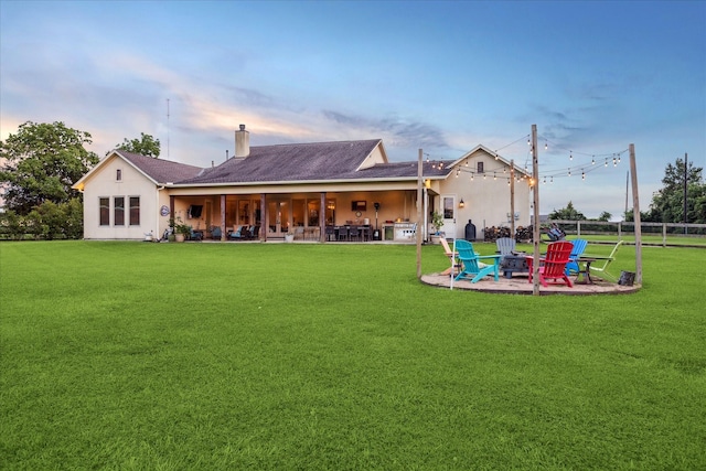 21319 Rosehill Church Rd, Tomball, TX 77377 - back of property at dusk featuring a fire pit, a patio area, a chimney, and stucco siding