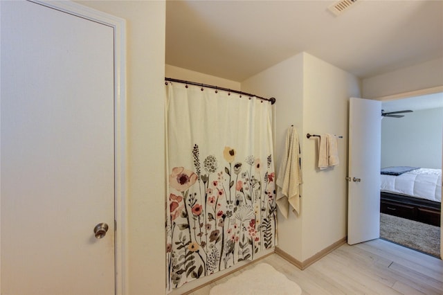 2910 Yearling Colt Ct, Houston, TX 77038 - ensuite bathroom with wood finished floors, a shower with shower curtain, and baseboards