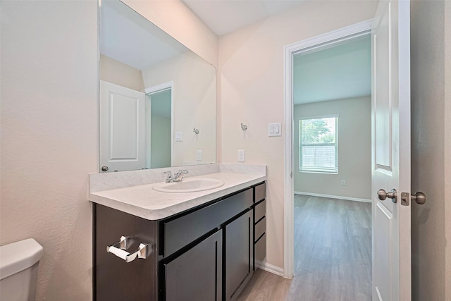 14627 Woodcott Warren Way, Pearland, TX 77545 - half bathroom featuring vanity, toilet, wood finished floors, and baseboards