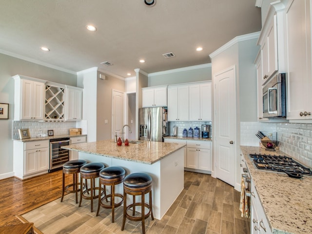 221 W 25th St Unit A, Houston, TX 77008 - kitchen with appliances with stainless steel finishes, beverage cooler, decorative backsplash, recessed lighting, and light wood-type flooring