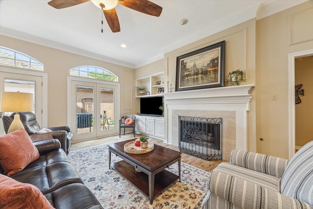 1902 Carriage Brook Way, Houston, TX 77062 - living area featuring light wood-type flooring, a ceiling fan, built in shelves, ornamental molding, and a tile fireplace