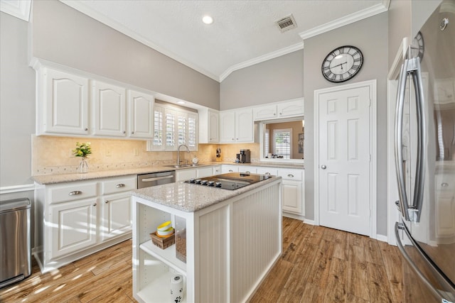 1902 Carriage Brook Way, Houston, TX 77062 - kitchen featuring appliances with stainless steel finishes, a sink, ornamental molding, white cabinets, and light wood-style flooring