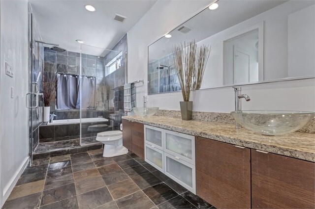 1604 Bastrop St, Houston, TX 77003 - full bathroom with double vanity, a shower stall, toilet, stone finish flooring, and recessed lighting