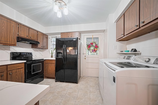 4304 Sherwood Ln Unit 106, Houston, TX 77092 - kitchen featuring black appliances, under cabinet range hood, washer and dryer, light tile patterned flooring, and light countertops