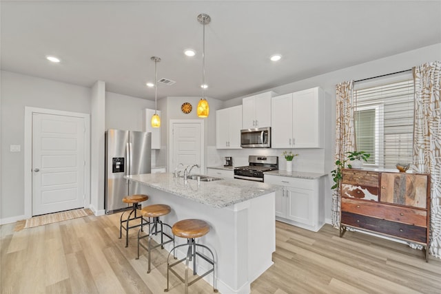 3125 Skyrock Dr, Houston, TX 77063 - kitchen with stainless steel appliances, a sink, light wood finished floors, a kitchen breakfast bar, and recessed lighting