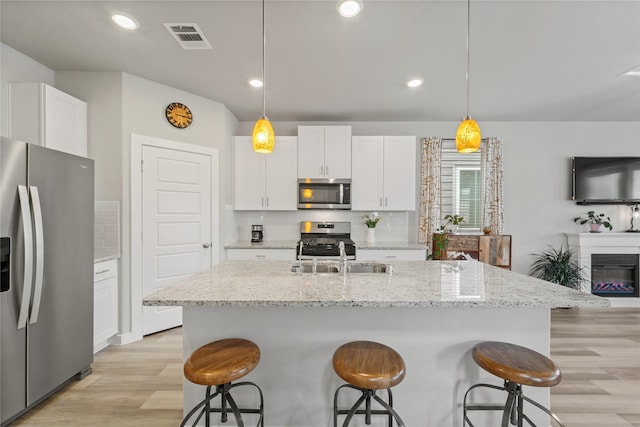 3125 Skyrock Dr, Houston, TX 77063 - kitchen featuring stainless steel appliances, backsplash, a breakfast bar area, a sink, and recessed lighting