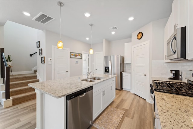 3125 Skyrock Dr, Houston, TX 77063 - kitchen with appliances with stainless steel finishes, a sink, light wood finished floors, tasteful backsplash, and recessed lighting
