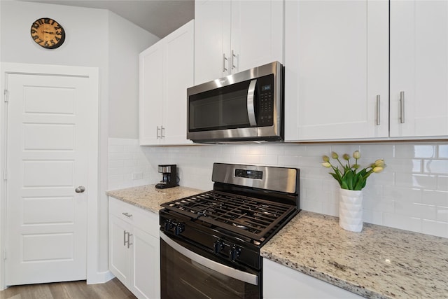 3125 Skyrock Dr, Houston, TX 77063 - kitchen with appliances with stainless steel finishes, light stone countertops, white cabinets, and tasteful backsplash
