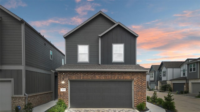 3125 Skyrock Dr, Houston, TX 77063 - view of front facade featuring brick siding, board and batten siding, a garage, and driveway