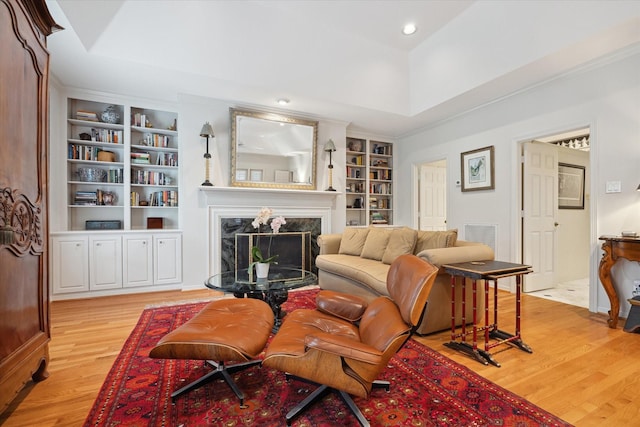 3633 Overbrook Ln, Houston, TX 77027 - living room with built in shelves, light wood-style floors, a high end fireplace, a tray ceiling, and recessed lighting