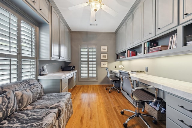3633 Overbrook Ln, Houston, TX 77027 - office area with built in study area, baseboards, light wood-style flooring, a ceiling fan, and ornamental molding