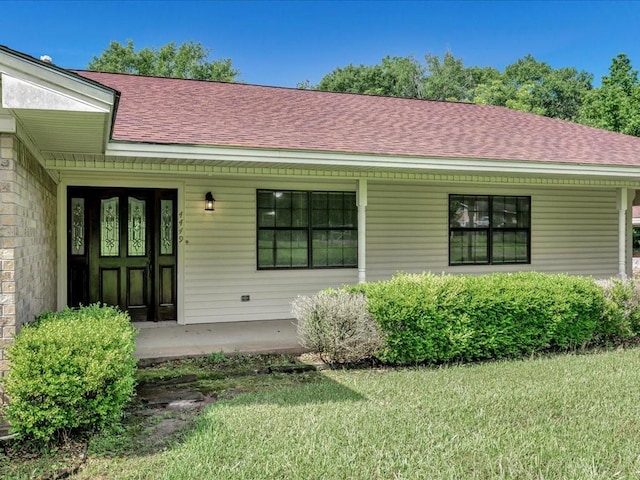 4449 Benton Rd, Lufkin, TX 75901 - view of exterior entry featuring a shingled roof, a yard, and covered porch