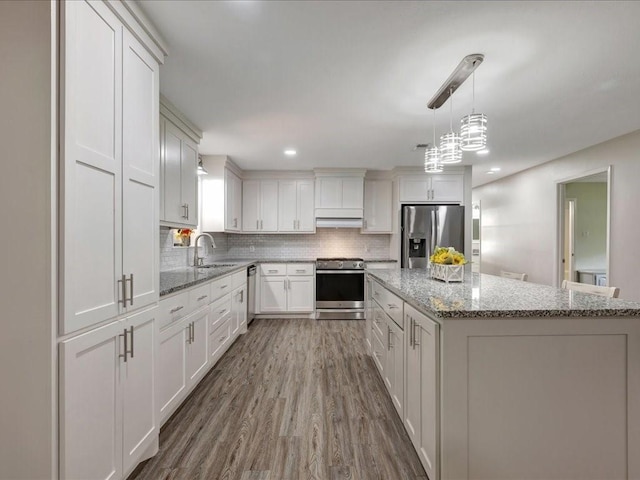 4449 Benton Rd, Lufkin, TX 75901 - kitchen featuring appliances with stainless steel finishes, a sink, backsplash, wood finished floors, and white cabinets