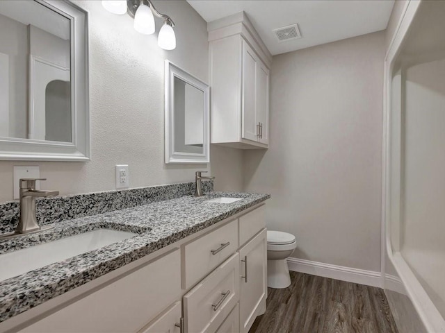 4449 Benton Rd, Lufkin, TX 75901 - full bathroom featuring toilet, double vanity, wood finished floors, and baseboards