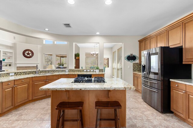 3610 Wellspring Lake Dr, Fulshear, TX 77441 - kitchen featuring a sink, appliances with stainless steel finishes, a kitchen island, brown cabinetry, and recessed lighting