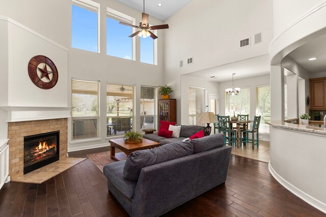 3610 Wellspring Lake Dr, Fulshear, TX 77441 - living room featuring a fireplace, dark wood-style flooring, ceiling fan, a high ceiling, and baseboards