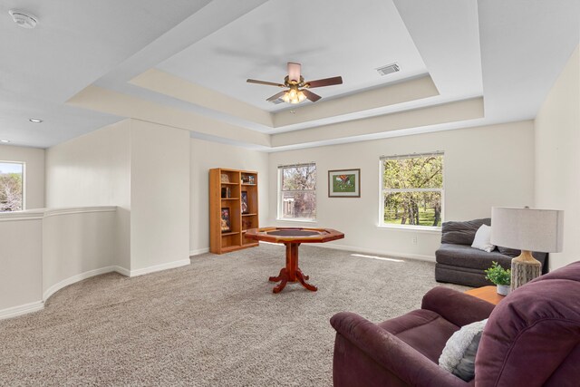 3610 Wellspring Lake Dr, Fulshear, TX 77441 - carpeted living area featuring a tray ceiling, healthy amount of natural light, baseboards, and ceiling fan