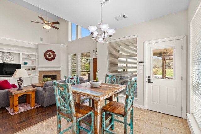 3610 Wellspring Lake Dr, Fulshear, TX 77441 - dining space with light tile patterned flooring, a ceiling fan, a chandelier, a fireplace, and built in features