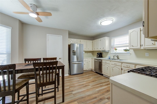 14927 Cypress Green Dr, Cypress, TX 77429 - kitchen featuring appliances with stainless steel finishes, a sink, light wood-type flooring, light countertops, and ceiling fan