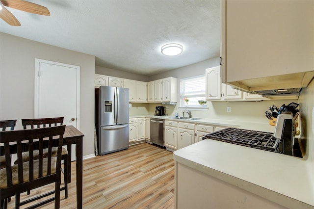 14927 Cypress Green Dr, Cypress, TX 77429 - kitchen with stainless steel appliances, a sink, light wood finished floors, light countertops, and ceiling fan