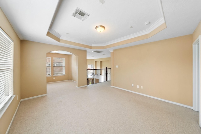 26 Oakmont Ct, Jersey Village, TX 77064 - spare room with a tray ceiling, arched walkways, light colored carpet, crown molding, and baseboards