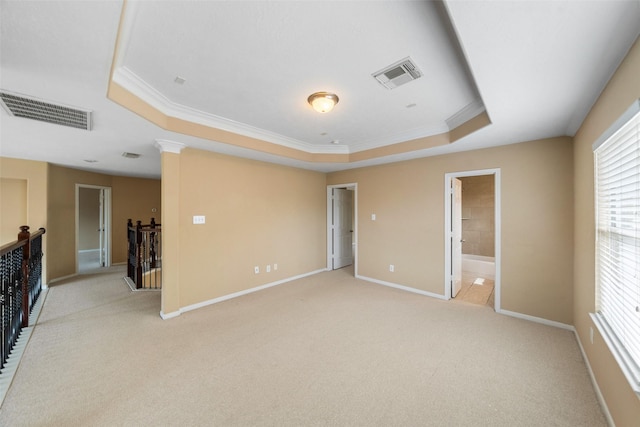 26 Oakmont Ct, Jersey Village, TX 77064 - spare room featuring a tray ceiling, ornamental molding, light colored carpet, and baseboards