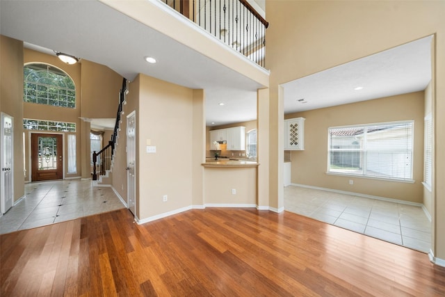 26 Oakmont Ct, Jersey Village, TX 77064 - foyer with light wood-style floors, stairs, a towering ceiling, baseboards, and recessed lighting
