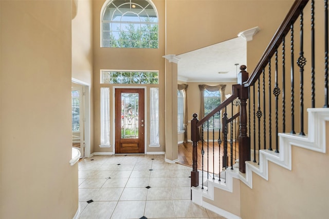 26 Oakmont Ct, Jersey Village, TX 77064 - tiled foyer featuring baseboards, stairway, crown molding, and a high ceiling