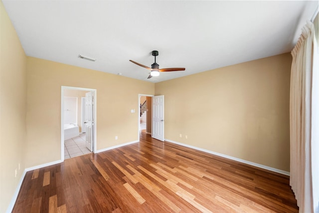 26 Oakmont Ct, Jersey Village, TX 77064 - unfurnished bedroom with light wood-style flooring, baseboards, connected bathroom, and a ceiling fan