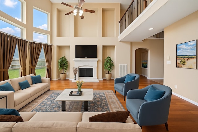 26 Oakmont Ct, Jersey Village, TX 77064 - living area featuring a high ceiling, ceiling fan, arched walkways, baseboards, and wood finished floors